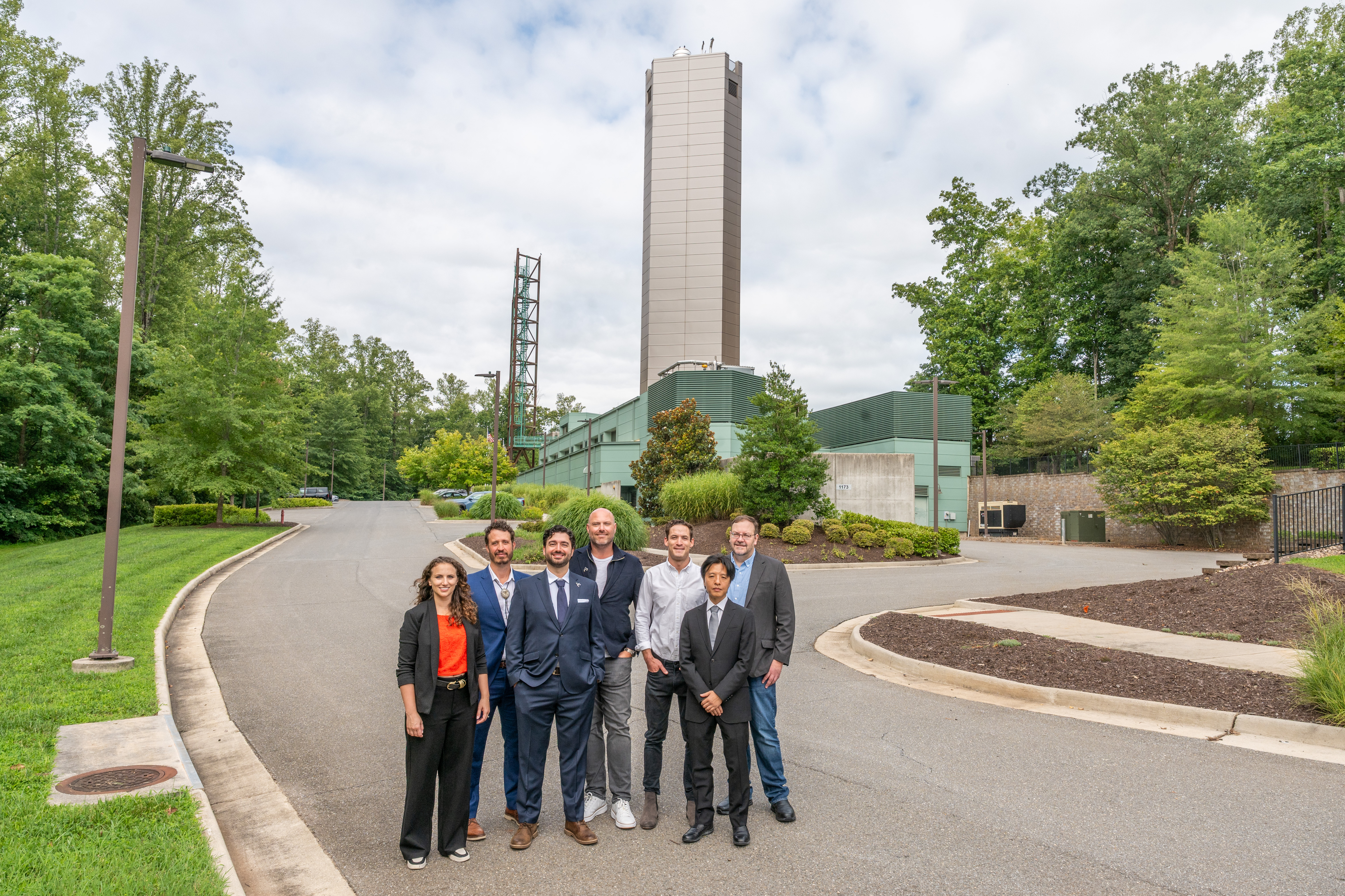 Applied team members standing in front of  the IST in the background from a farther away angle 